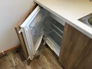an empty refrigerator in a kitchen next to a sink at Apartment Šárka in Strupčice +18 photos