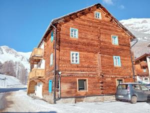 a wooden barn with a car parked in front of it at canton 520 appartamenti self check in in Livigno
