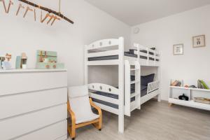 une chambre avec des lits superposés blancs et une chaise dans l'établissement StayCozy Bike&Ski Apartments, eigener Fahrrad- und Skikeller, barrierefrei, Erdgeschoss, à Winterberg