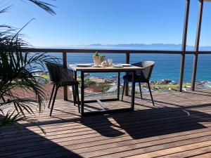 una mesa y sillas en una terraza con vistas al océano en Oceans Drift Guest House & Self Catering, en Simonʼs Town 10 fotos más