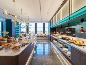 a buffet line in a restaurant with food at Novotel Shanghai Lingang in Nanhui