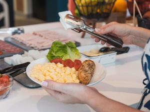 a person holding a plate of food on a table at ibis budget Madrid Albasanz in Madrid