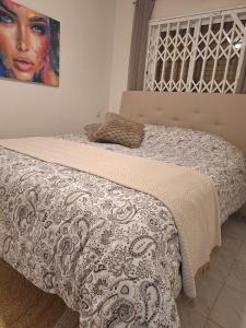 Dos camas en un dormitorio con un cuadro en la pared. en Het Verwende Nest, en La Mata