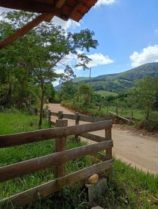a fence on the side of a dirt road at Chalé Mandala de Pedra in São Thomé das Letras