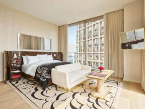 una habitación de hotel con una cama y una silla en Faena New York, en Nueva York