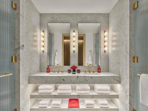 un baño con dos lavabos y dos espejos en Faena New York, en Nueva York 34 fotos más
