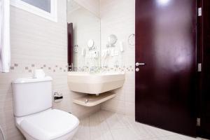 um banheiro com um vaso sanitário branco e uma pia em Comfy Furnished Studio Apartment no Dubai