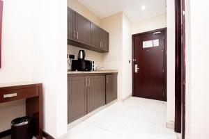 uma cozinha com armários de madeira e uma porta em Comfy Furnished Studio Apartment no Dubai