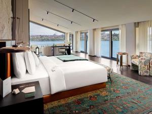 a bedroom with a large bed with a large window at Aliée Istanbul - A Paris Society Collection Hotel in Istanbul