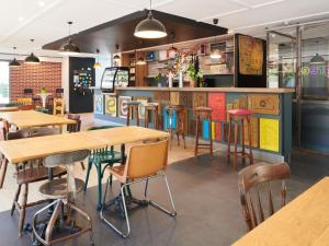 un restaurant avec des tables et des chaises en bois dans l'établissement Greet Hôtel Saint-Nazaire Trignac Nouvelle Marque du Groupe Accor, à Trignac 44 autres photos