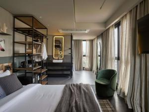 ein Hotelzimmer mit einem Bett und einem Stuhl in der Unterkunft TRIBE Belo Horizonte Savassi in Belo Horizonte