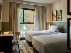 une chambre d'hôtel avec deux lits et une fenêtre dans l'établissement TRIBE Belo Horizonte Savassi, à Belo Horizonte 153 autres photos