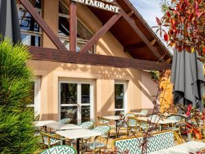 Un patio con mesas y sillas frente a un edificio. en ibis Styles Chartres Sud Barjouville, en Chartres