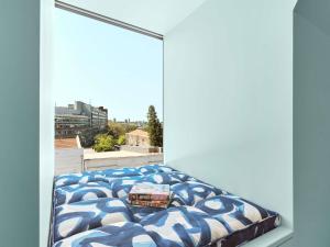 a bed in a room with a window at 25hours Hotel Sydney The Olympia in Sydney +101 photos