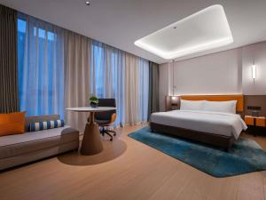 a bedroom with a bed and a couch and a table at Novotel Hangzhou Xintiandi in Hangzhou +110 photos