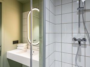 ein Badezimmer mit Dusche, Waschbecken und Spiegel in der Unterkunft greet Hotel Reims Tinqueux in Reims + 93 Fotos