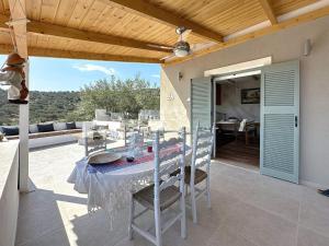 un patio avec une table et des chaises sur un balcon dans l'établissement Villa Kristina, Ermioni, à Plépi