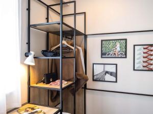 a room with a book shelf and a table at ibis Bordeaux Nord Carbon Blanc in Carbon-Blanc