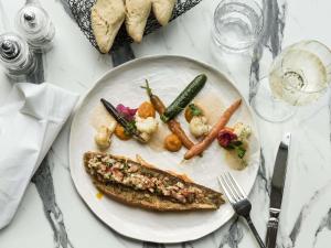 a plate of food with fish and vegetables on a table at Mercure Chartres Est in Chartres