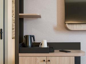 a kitchen counter with a coffee pot on top of it at Mercure Chartres Est in Chartres