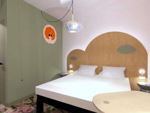 Un dormitorio con una cama grande con cabecero de madera. en ibis Styles Metz Centre, en Metz