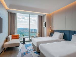 ein Hotelzimmer mit zwei Betten und einem Fenster in der Unterkunft Novotel Huzhou South Taihu Lake in Huzhou + 55 Fotos