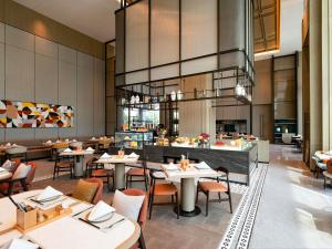 ein Esszimmer mit Tischen und Stühlen und ein Restaurant in der Unterkunft Novotel Huzhou South Taihu Lake in Huzhou