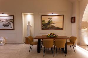 Un comedor con mesa y sillas de madera. en Captain's House Hotel Suites & Apartments, en Panormos Rethymno