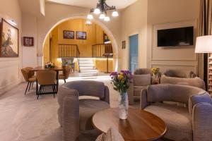 una sala de estar con sillas y una mesa en Captain's House Hotel Suites & Apartments, en Panormos Rethymno