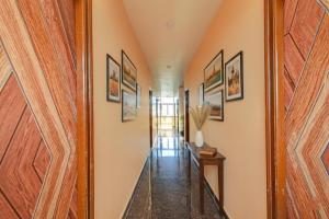 un pasillo con una puerta y pinturas en las paredes en FabHotel PVR, en Hyderabad