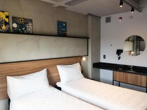 deux lits dans une chambre avec deux lits blancs dans l'établissement ibis Arcoverde, à Arcoverde