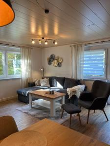 a living room with a couch and a table at Rottal-AlpakaLodge Zeit zu Zweit im Grünen in Abtsgmünd