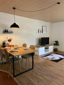 a dining room with a table and chairs and a television at Rottal-AlpakaLodge Zeit zu Zweit im Grünen in Abtsgmünd +77 photos