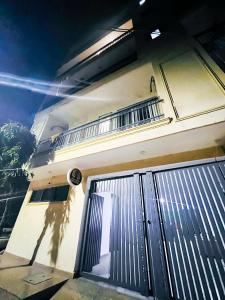 a white house with a gate and a balcony at Hotel 24 Stay - Near Max Hospital in New Delhi