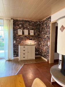 a living room with a stone wall at Rottal-AlpakaLodge Zeit zu Zweit im Grünen in Abtsgmünd