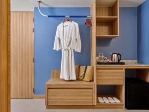 Mercure Phuket Patong Journeyhub في شاطيء باتونغ: رداء أبيض معلق على رف في مطبخ