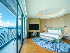 une chambre d'hôtel avec un lit et un balcon dans l'établissement The Morning Glow - Handwritten Collection, à Nha Trang