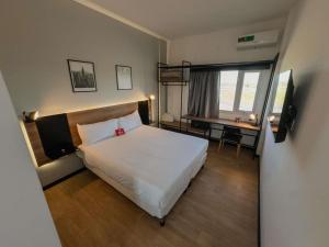 sypialnia z łóżkiem i biurkiem z telewizorem w obiekcie Ibis Puerto General San Martin w mieście San Lorenzo