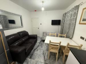 un salon avec un canapé et une table dans l'établissement Modern 2 bedrooms Apartment- Ashton-Under-Lyne- Hosts 5 persons, à Ashton-under-Lyne