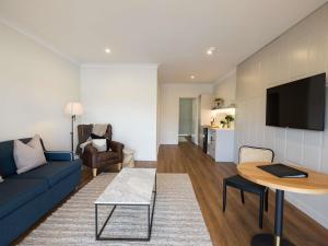 Una sala de estar con un sofá azul y una mesa. en Clare Country Club, en Clare