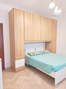 a bedroom with a bed and wooden cabinets at Trilocale vacanza Riccione in Riccione