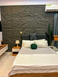 a bedroom with a large white bed with a green pillow at Double Bed with balcony in Lagos