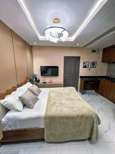 a bedroom with a large bed and a television at Double Bed with balcony in Lagos