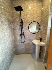 a bathroom with a shower and a sink and a mirror at Double Bed with balcony in Lagos