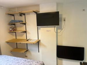 ナタールにあるPrático 228のベッドルーム1室(壁にテレビ付)、ベッド1台が備わります。