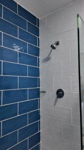 ducha con pared de azulejos azules y blancos en Diani Sands International Hotel, en Galu
