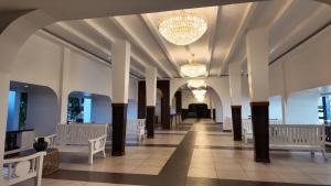 un couloir avec des colonnes et des lustres dans un bâtiment dans l'établissement Diani Sands International Hotel, à Galu 99 autres photos
