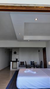 Un dormitorio con una gran cama blanca y sillas. en Diani Sands International Hotel, en Galu