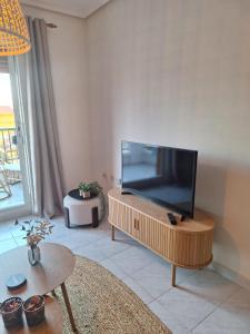 Una sala de estar con un televisor de pantalla plana grande. en Het Verwende Nest, en La Mata