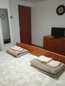 two folded towels are sitting on top of a bed at Vila Petrov in Lukavica